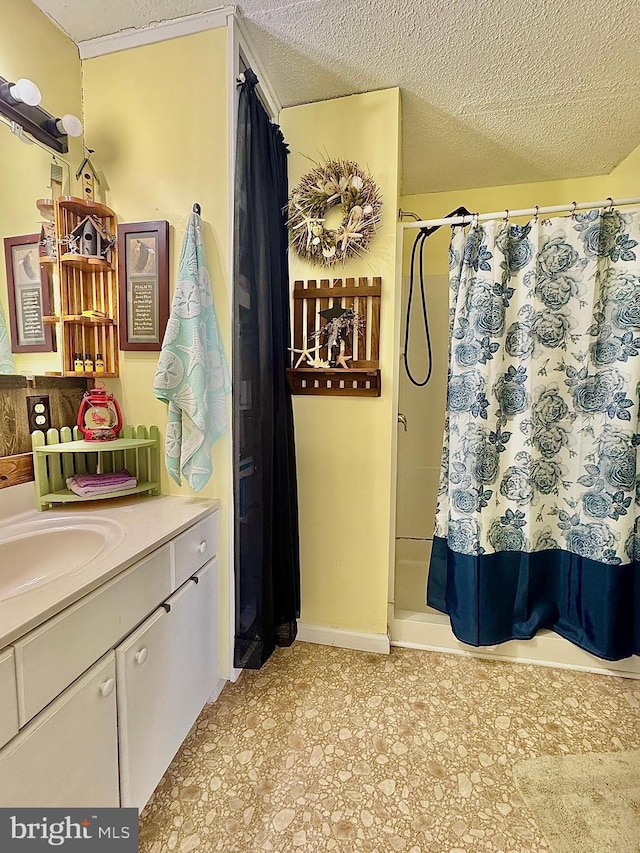 full bath with a shower with shower curtain, a textured ceiling, and vanity