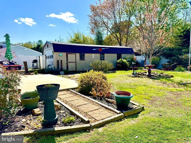 exterior space with a lawn, fence, and an outdoor structure