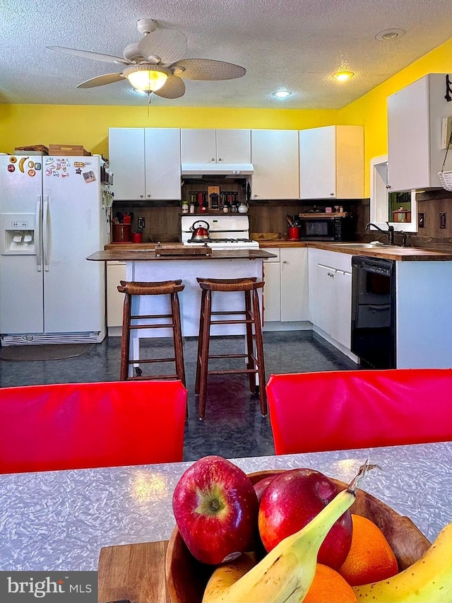 kitchen with black appliances, a textured ceiling, white cabinetry, and a sink