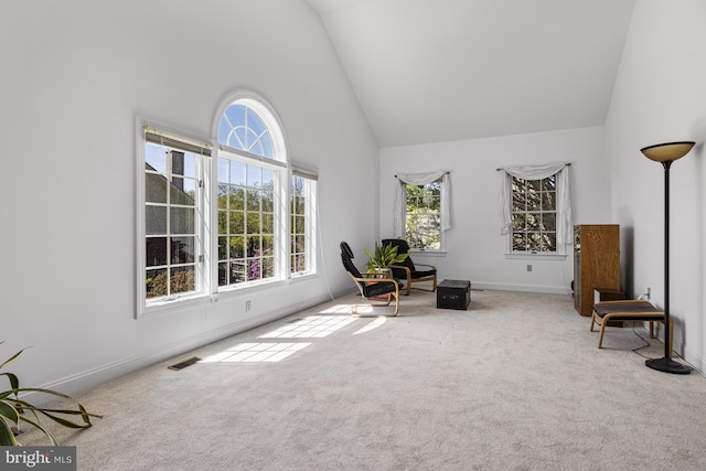 unfurnished room featuring baseboards, carpet flooring, a healthy amount of sunlight, and high vaulted ceiling
