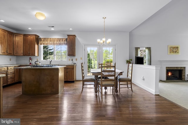 kitchen with tasteful backsplash, a kitchen island, dark wood finished floors, and a chandelier