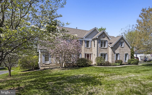 view of front of home with brick siding and a front yard