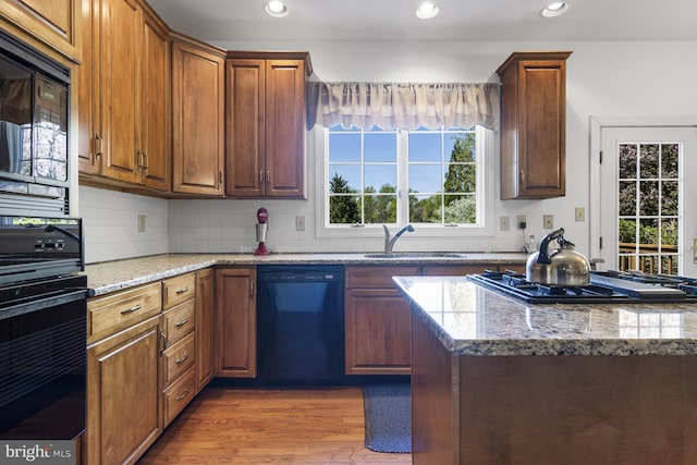 kitchen with dark wood-type flooring, a sink, black appliances, and recessed lighting