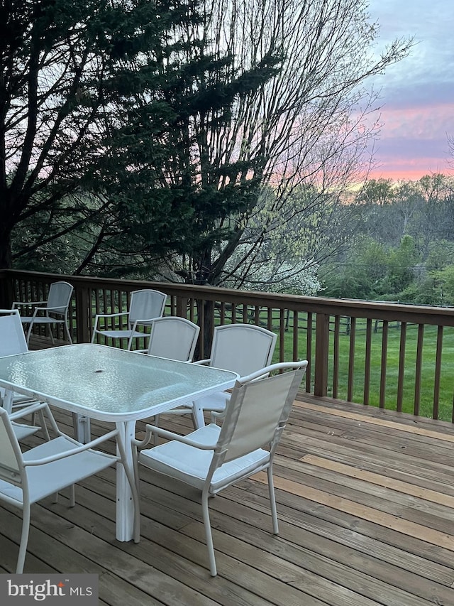 deck at dusk with outdoor dining space