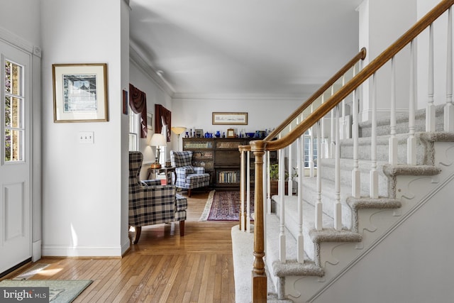 entryway featuring stairway, baseboards, crown molding, and wood-type flooring