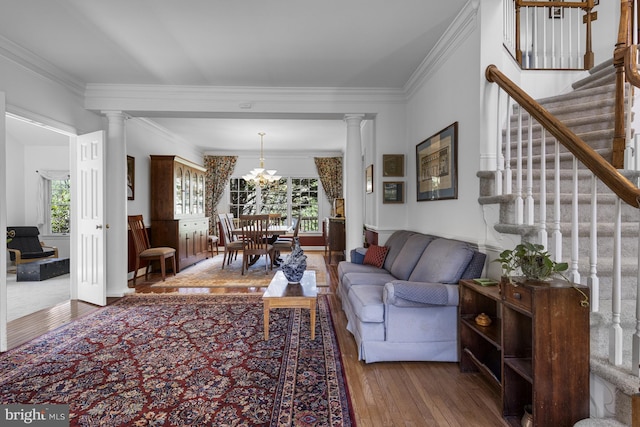 living area with wood-type flooring, decorative columns, a healthy amount of sunlight, and stairway