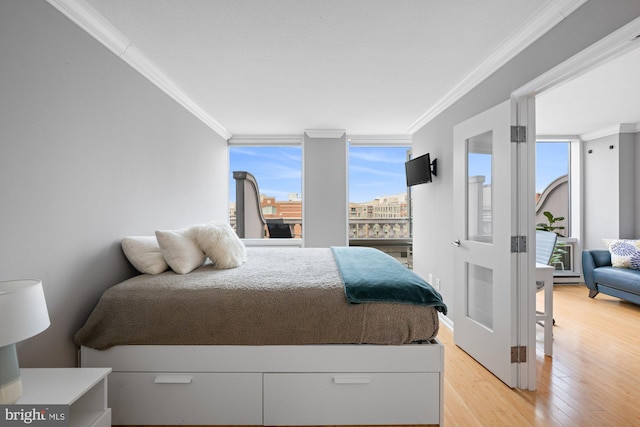bedroom featuring crown molding and light wood-style floors