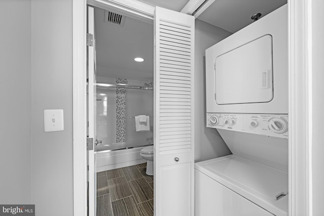clothes washing area with laundry area, recessed lighting, stacked washer / dryer, and visible vents