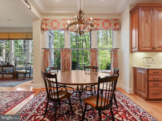 dining room with a healthy amount of sunlight, baseboards, light wood-type flooring, and a chandelier