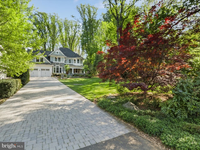 view of front of house featuring a garage, driveway, and a front yard
