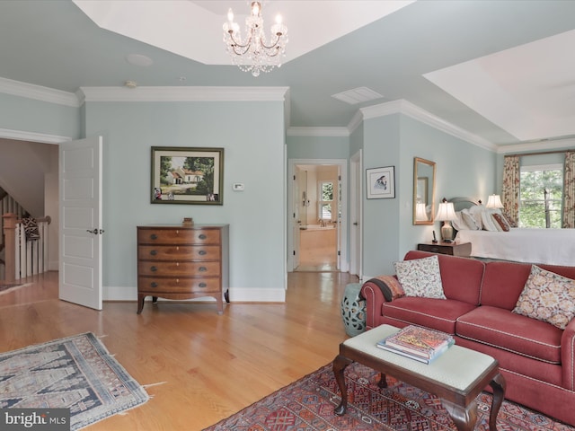 living room featuring crown molding, a notable chandelier, visible vents, and wood finished floors