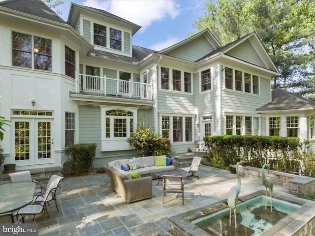rear view of property with an outdoor hangout area, a patio area, and a balcony