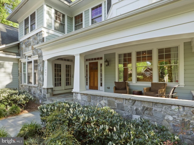 property entrance featuring a porch and stone siding