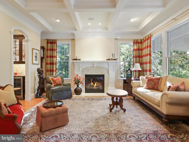 living room with wine cooler, wood finished floors, beamed ceiling, a high end fireplace, and coffered ceiling