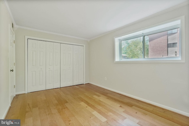 unfurnished bedroom with light wood-type flooring, baseboards, and crown molding