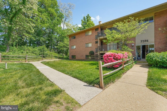 view of property's community featuring fence and a yard