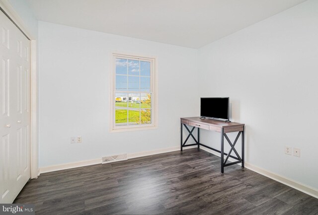unfurnished bedroom with dark wood-type flooring, visible vents, and baseboards