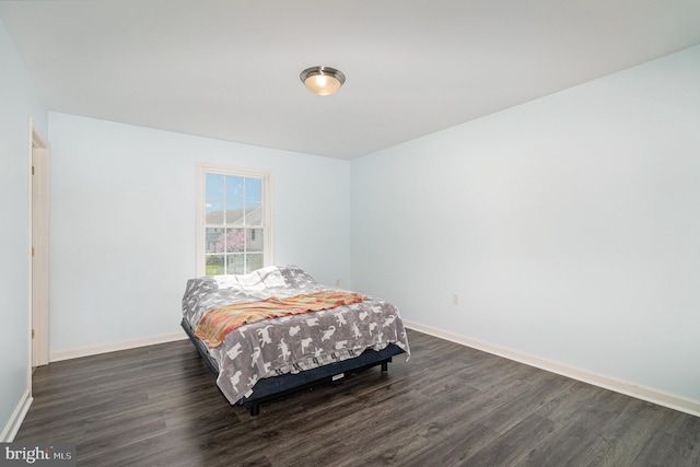 bedroom featuring dark wood-style floors and baseboards