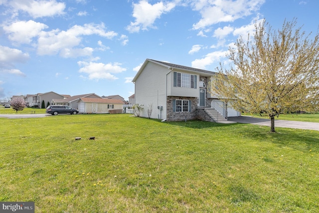 exterior space featuring a lawn, driveway, and stone siding