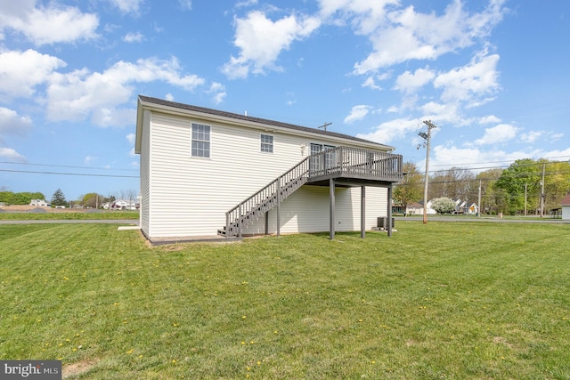 rear view of property with a deck, cooling unit, a lawn, and stairs