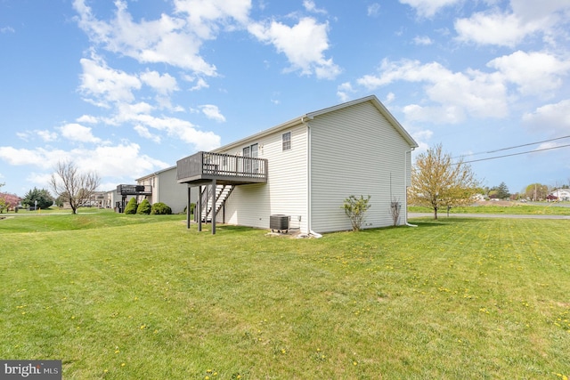 view of property exterior with a lawn, a wooden deck, central AC, and stairs