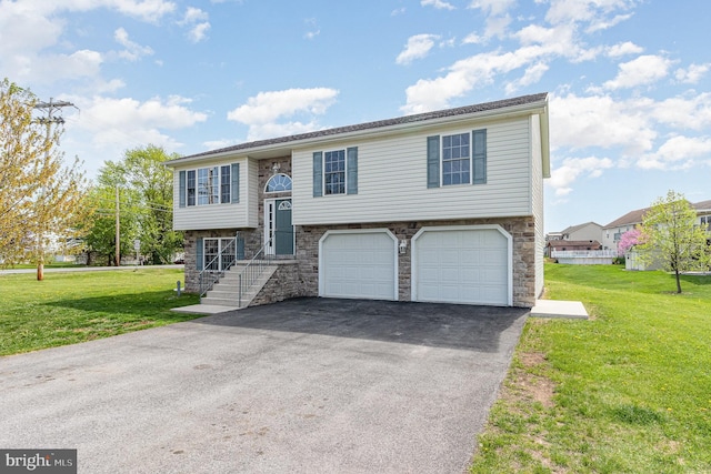 bi-level home with a front yard, stone siding, aphalt driveway, and a garage