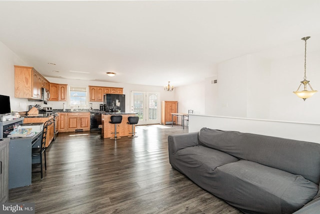 living area featuring visible vents, a chandelier, and dark wood finished floors