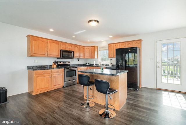 kitchen with black fridge, dark countertops, stainless steel electric range oven, and dark wood finished floors