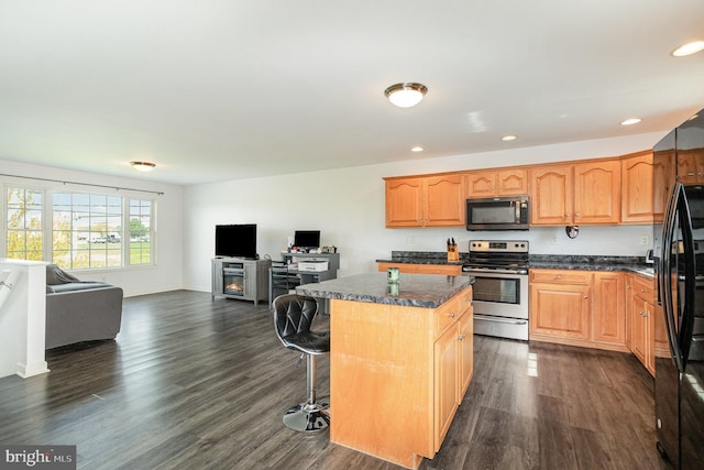 kitchen featuring recessed lighting, freestanding refrigerator, a kitchen island, stainless steel electric stove, and open floor plan
