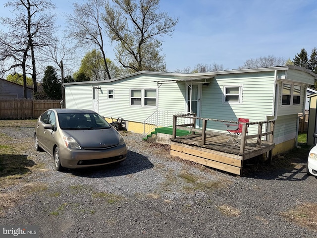 view of front of house with fence and a deck