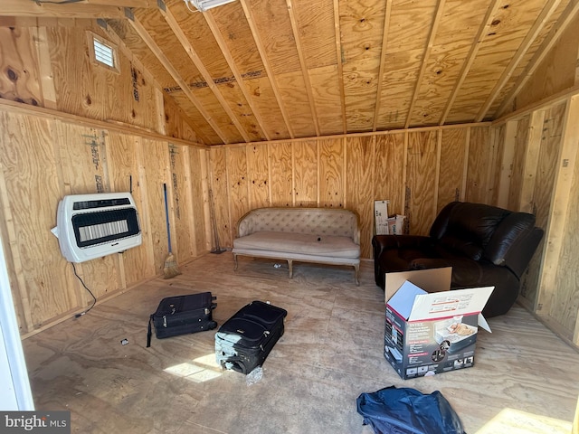 unfurnished room with wood walls, heating unit, and lofted ceiling