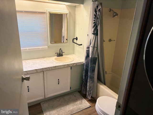 full bathroom featuring toilet, wood finished floors, shower / tub combo, and vanity