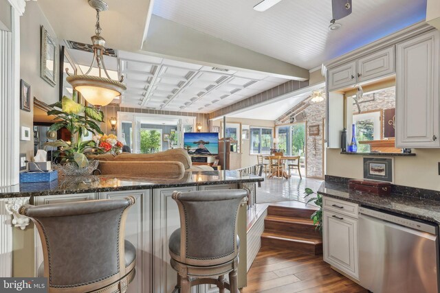1511 Glenview Dr, Cinnaminson, NJ 08077 - kitchen with dishwasher, hardwood / wood-style floors, a breakfast bar, lofted ceiling, and dark stone countertops