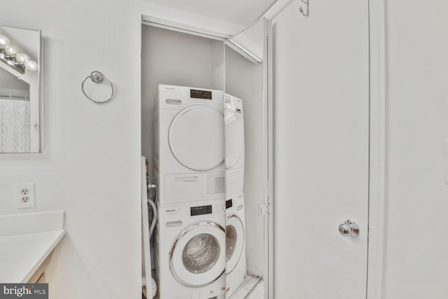 clothes washing area with stacked washer / drying machine and laundry area