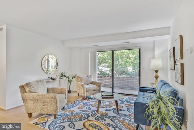 living area featuring baseboards, wood finished floors, and visible vents