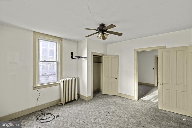 unfurnished bedroom with a ceiling fan, baseboards, carpet, and radiator