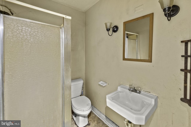 bathroom with a sink, a shower stall, and toilet