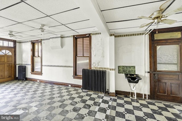 foyer featuring radiator heating unit, baseboards, a ceiling fan, and tile patterned floors