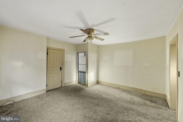 carpeted empty room featuring baseboards and a ceiling fan