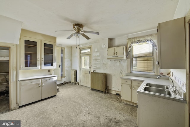 kitchen featuring radiator heating unit, light countertops, ceiling fan, and a sink