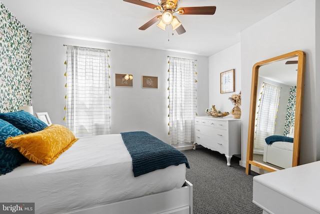 carpeted bedroom featuring ceiling fan and multiple windows