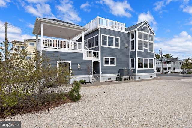 rear view of house with a balcony and cooling unit