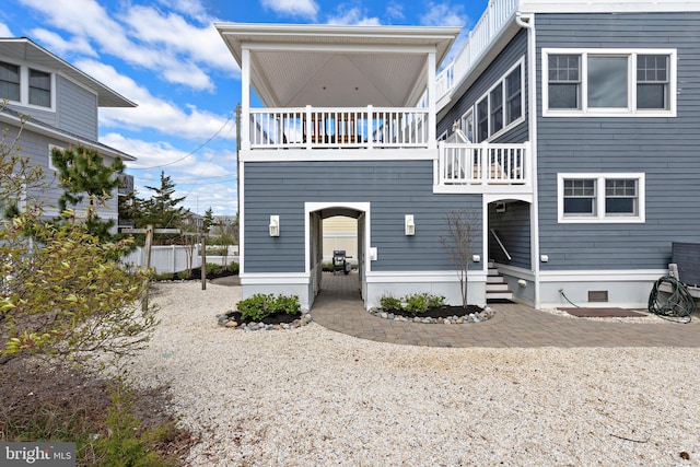 view of front of property featuring fence and a balcony