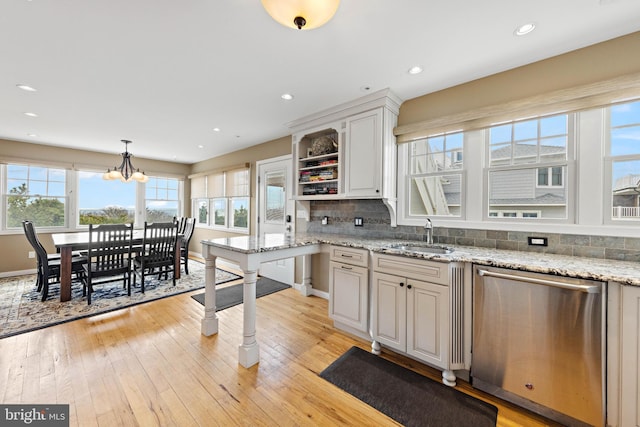 kitchen with open shelves, a sink, dishwasher, decorative backsplash, and light wood-type flooring