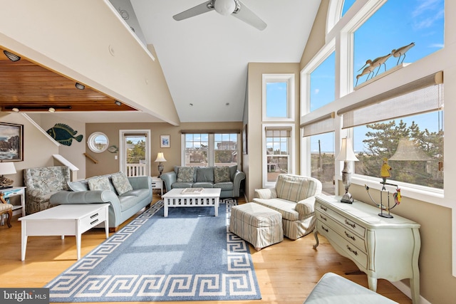 living area featuring high vaulted ceiling, a ceiling fan, and wood finished floors