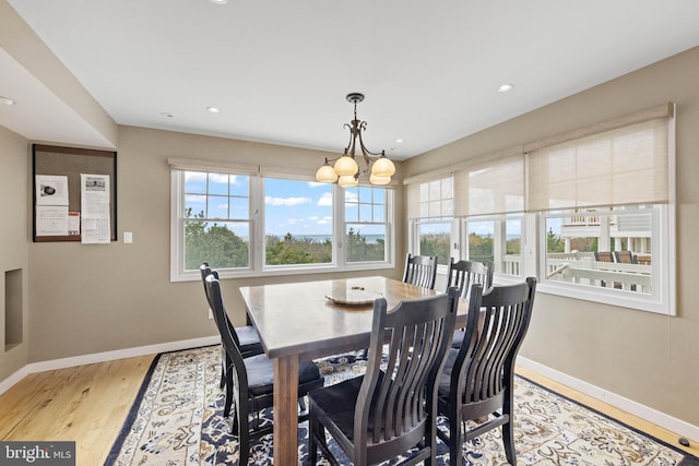 dining area with recessed lighting, baseboards, a notable chandelier, and light wood-style floors
