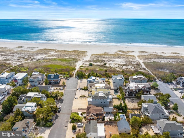 aerial view featuring a beach view, a water view, and a residential view