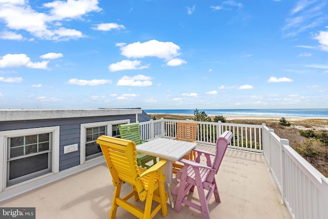 balcony featuring outdoor dining area, a beach view, and a deck with water view