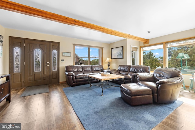 living room featuring beamed ceiling and wood finished floors