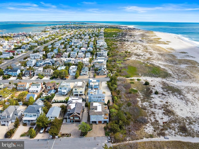 bird's eye view featuring a water view, a beach view, and a residential view